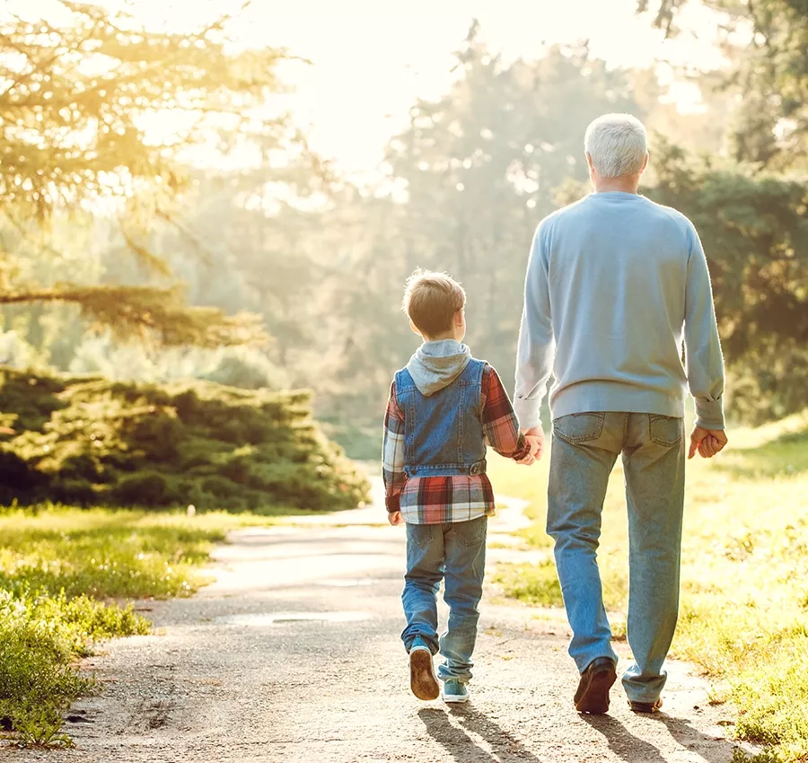 Mann der Hörgeräte trägt geht mit seinem Enkel spazieren